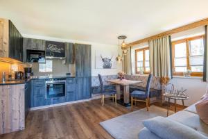 a kitchen and living room with blue cabinets and a table at Appartements Lehenhof in Sankt Johann im Pongau