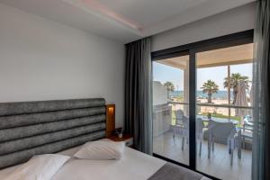 a bedroom with a bed and a view of the ocean at Amalia Mare in Nea Vrasna +165 photos