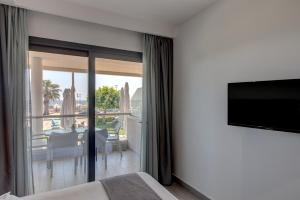 a bedroom with a flat screen tv on a wall at Amalia Mare in Nea Vrasna