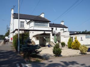 a white building with a sign on the front of it at Cheshire Yeoman - Station Hotel in Hooton Station