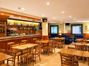 a restaurant with tables and chairs and a bar at Hotel Casado in Pas de la Casa