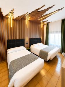a hotel room with two beds in it at Hotel Casado in Pas de la Casa
