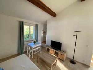a living room with a bed and a table with a television at Studio au 1er étage à la campagne in Callian