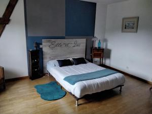 a bedroom with a bed and a blue rug at Chambre à la campagne in Saint-Eustache-la-Forêt +2 photos