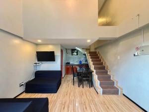 a living room with a staircase with a couch and a table at Sea Break La Union in Balio