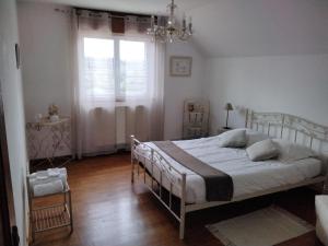 a bedroom with a white bed and a window at Chambre à la campagne in Saint-Eustache-la-Forêt