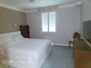 a bedroom with a white bed and a window at Grand appartement familiale in Issoire
