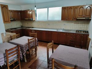 a kitchen with wooden cabinets and tables and two tables at BNB Alehandro in Radhimë