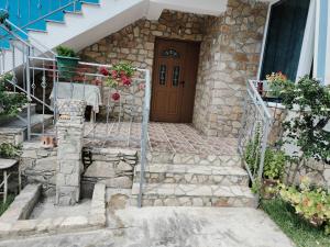 a set of stone stairs leading to a wooden door at BNB Alehandro in Radhimë