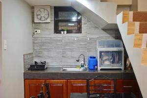a small kitchen with a sink and a microwave at Sea Break La Union in Balio