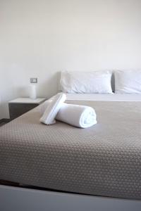 a white bed with a towel on top of it at Pierre Palace in Isola Sacra