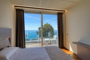 ein Schlafzimmer mit Bett und Meerblick in der Unterkunft Hotel Le Roi in Varraze + 59 Fotos