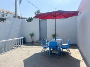 a table and chairs with a red umbrella on a patio at Your Getaway Home in Yerevan +20 photos