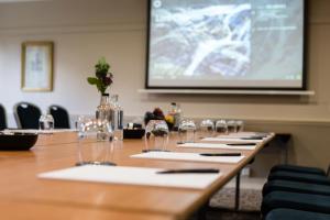 a conference room with a long table with wine glasses at Audleys Wood Hotel, Basingstoke in Basingstoke