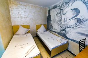 two beds in a room with a painting on the wall at Casa Yachi Vama Veche in Vama Veche +80 photos