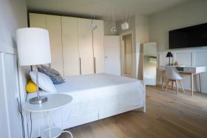 a bedroom with a white bed and a table with a lamp at La Corte 27 - A in Sesto Calende