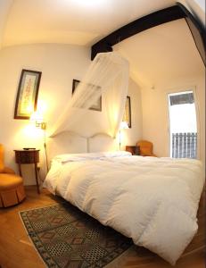 1 dormitorio con 1 cama blanca grande con mosquitera en B&B Da Gilberto, en Cividale del Friuli