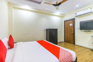 a bedroom with a bed and a flat screen tv at Hotel Pleasure Palace in Indore
