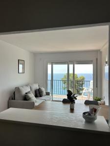 a living room with a couch and a view of the ocean at Apartamentos Cala Llevado in Tossa de Mar +206 photos
