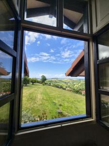 a window view of a field from a house at Posada torre del milano in Comillas