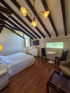a bedroom with a bed and a table and chairs at Posada torre del milano in Comillas
