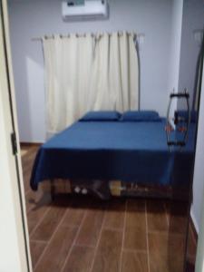 a bedroom with a blue bed with a curtain at Casa veraneio in Soure