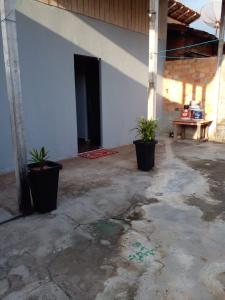 an empty room with two potted plants and a table at Casa veraneio in Soure