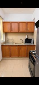 a kitchen with wooden cabinets and a sink and a microwave at Étoile in Pointe-Noire