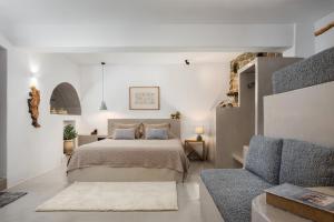 a bedroom with a bed and a blue chair at Vivian Dio Choria Tinos in Dhió Kkhoriá