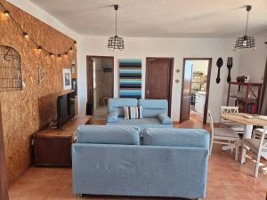 a living room with a blue couch and a tv at Casa Elsa in Puerto del Rosario