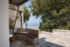 a bench sitting on the side of a house at Vivian Dio Choria Tinos in Dhió Kkhoriá