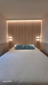a bedroom with a large bed with two blue pillows at Residence Club Inn in Nice