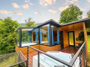 a glass house with a hot tub on a deck at Hill House Merisi in Merisi