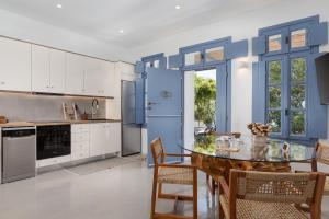 a blue kitchen with a table and chairs at Vivian Dio Choria Tinos in Dhió Kkhoriá