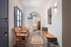 a hallway with a table and chairs and a door at Vivian Dio Choria Tinos in Dhió Kkhoriá +22 photos