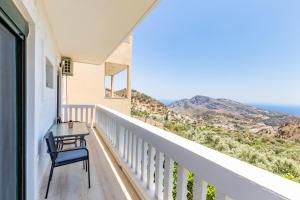 a balcony with a chair and a view of the ocean at Villa Maria in Voládha