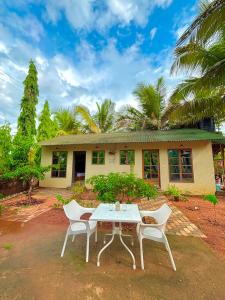 a table and chairs in front of a house at Harmals Studios & Apartments in Arambol