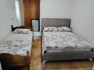 a bedroom with two beds and a refrigerator at BNB Alehandro in Radhimë