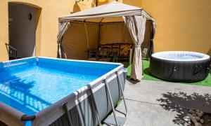 a swimming pool with an umbrella and a hot tub at Dimora RAVENNA CORTE CHARME Diaz in Ravenna