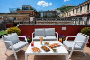 a table and chairs with food on a patio at La Ciliegina Lifestyle Hotel in Naples