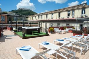 a patio with white lounge chairs and a grill at La Ciliegina Lifestyle Hotel in Naples