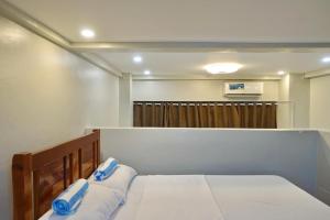 a bedroom with a bed with blue pillows on it at Sea Break La Union in Balio