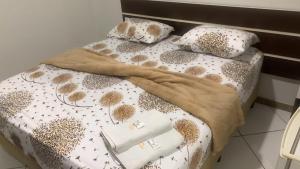 a bed with a comforter and pillows on it at Hotel União in Pojuca +9 photos