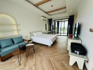 a bedroom with a bed and a couch and a tv at Aviera Boutique in Liên Trì (4)