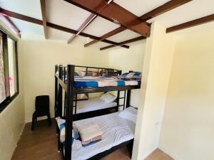 a room with two bunk beds in a room at Jeden Glass House Mountain View in Canayan