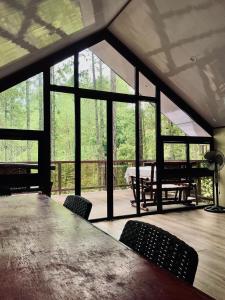 a large room with a large table and chairs at Jeden Glass House Mountain View in Canayan