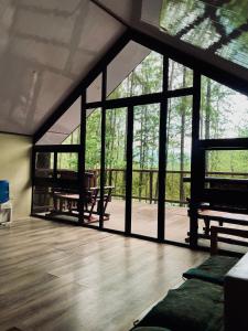 a room with large windows and a wooden floor at Jeden Glass House Mountain View in Canayan +7 photos