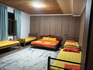 a room with three beds and a rug at SALEM hotel in Türkistan