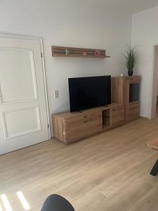 a living room with a flat screen tv on a wooden entertainment center at Ferienwohnung Jach in Triglitz