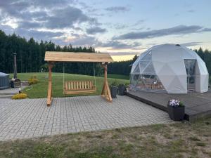 a tent and a bench on a patio at Atostogų namelis Stebuliuose in Stebuliai